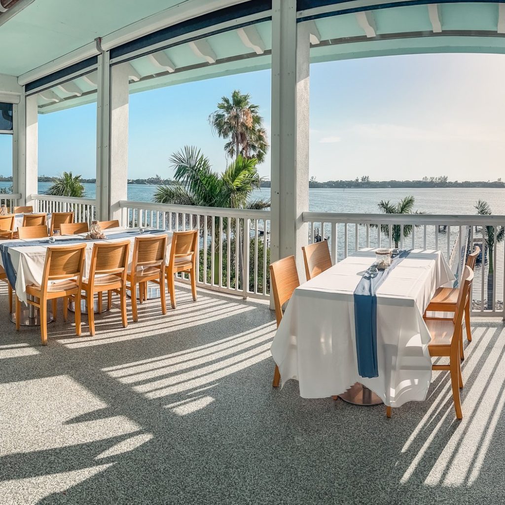 Waterfront dining setup with tables, white linens, and bay views at The Point.