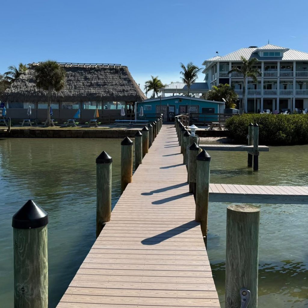 Dock leading to Evie’s on the Bay with the tiki bar and waterfront restaurant in the background.